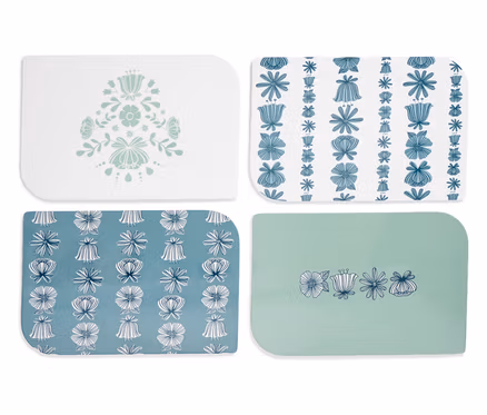 Quatre dessous de verre rectangulaires avec des motifs floraux en bleu et blanc.