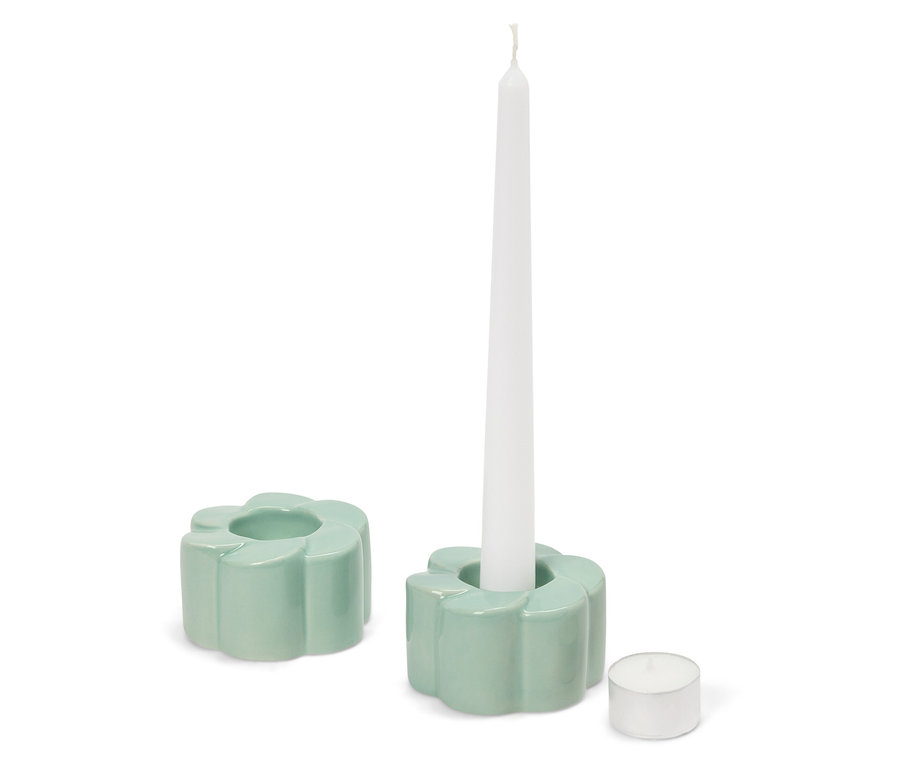 Deux bougeoirs vert clair en forme de fleur, l'un avec une bougie blanche, et une bougie chauffe-plat à côté.