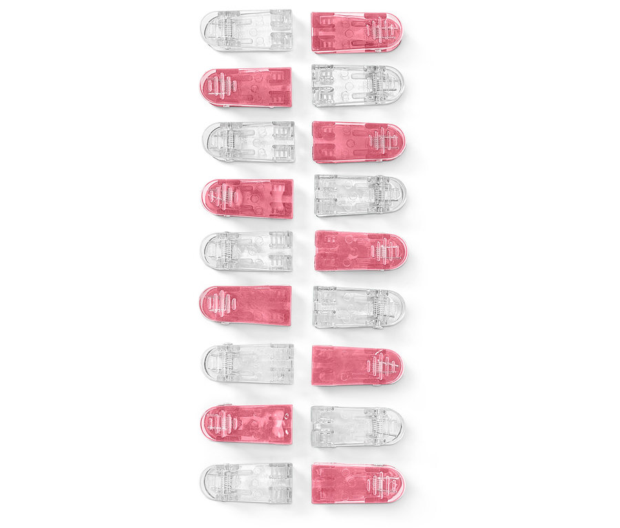Gros plan de 20 pinces à linge en tissu, alternativement roses et transparentes.