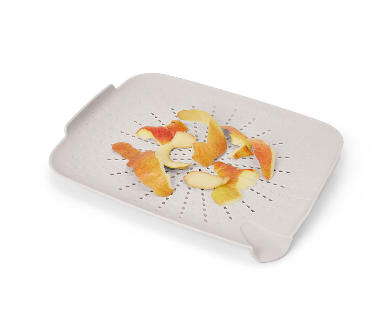 Un tamis plat gris pour évier avec des épluchures de pommes dessus.