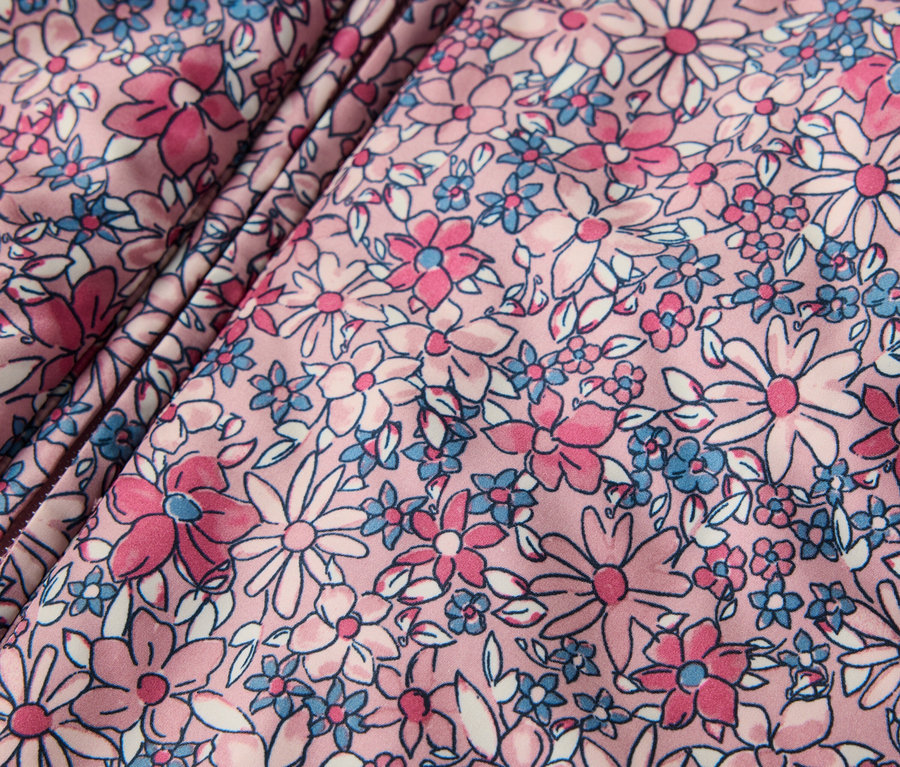 Gros plan d'une combinaison d’hiver pour bébé avec un motif floral.