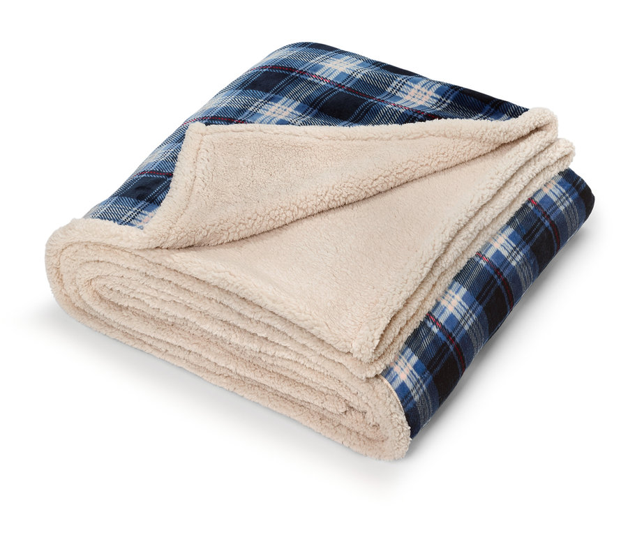 Couverture pliée à carreaux bleus avec doublure en sherpa crème.