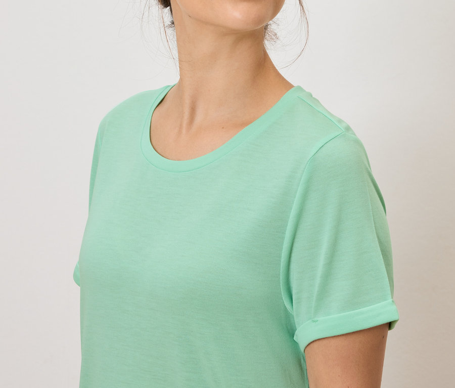 Une femme porte un t-shirt vert clair.