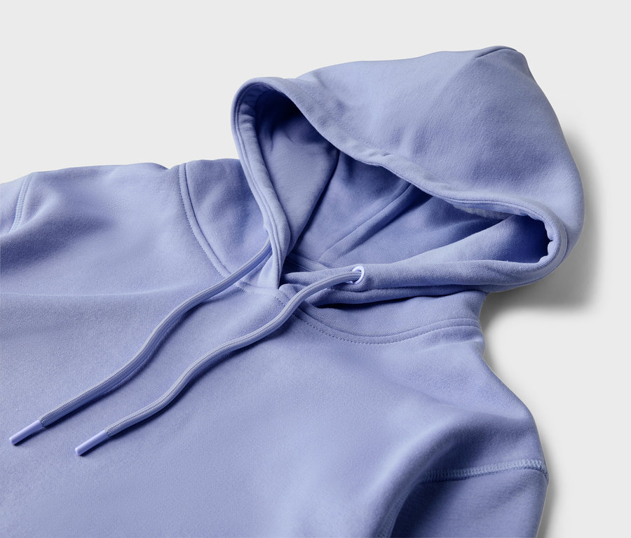 Vue détaillée d'un sweat à capuche violet clair avec cordon de serrage sur un fond clair.
