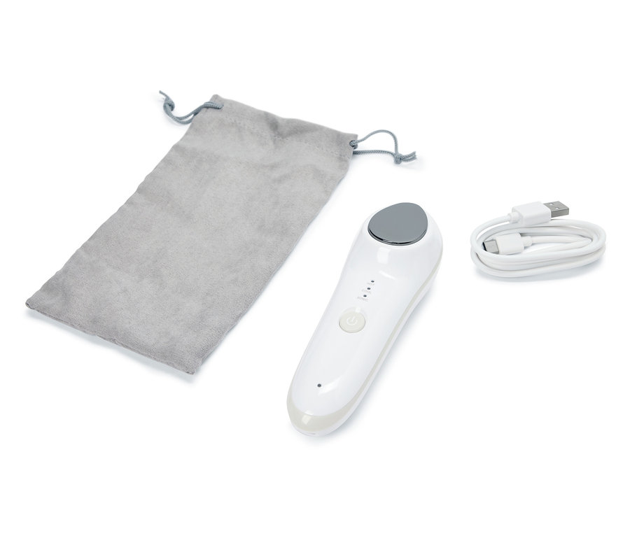 Un masseur facial vibrant 4 en 1, une pochette grise et un câble USB sont posés sur un fond blanc.