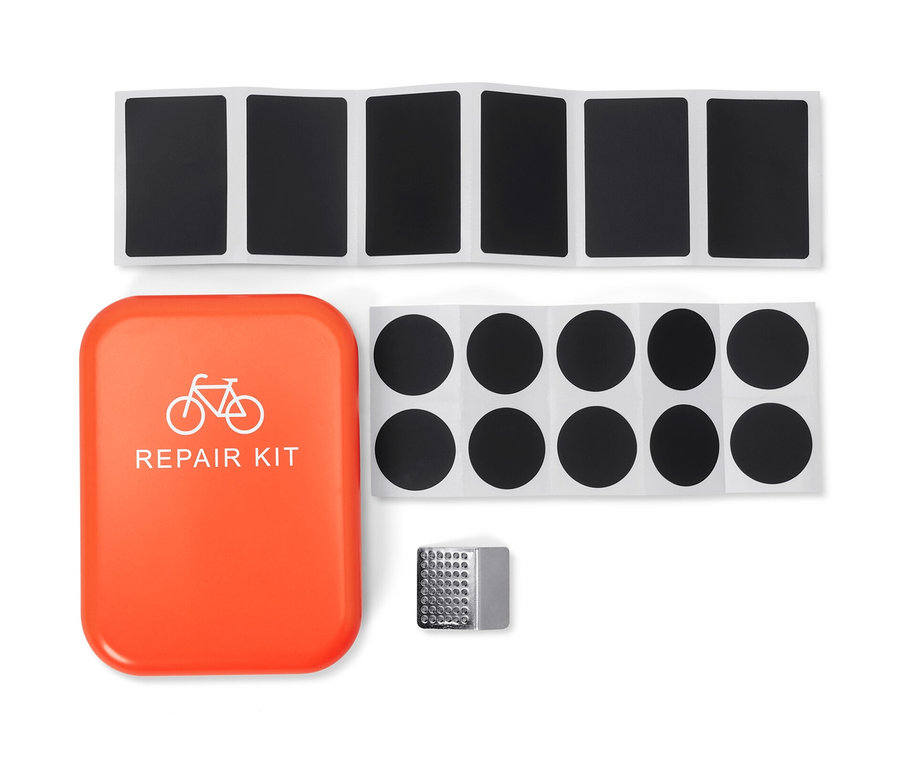 Kit de réparation vélo avec étui orange, rustines et papier de verre.