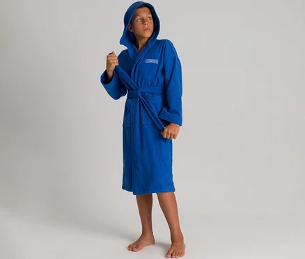 Garçon portant un peignoir pour enfant arena Zeppelin Light JR bleu à capuche, regardant vers le haut.