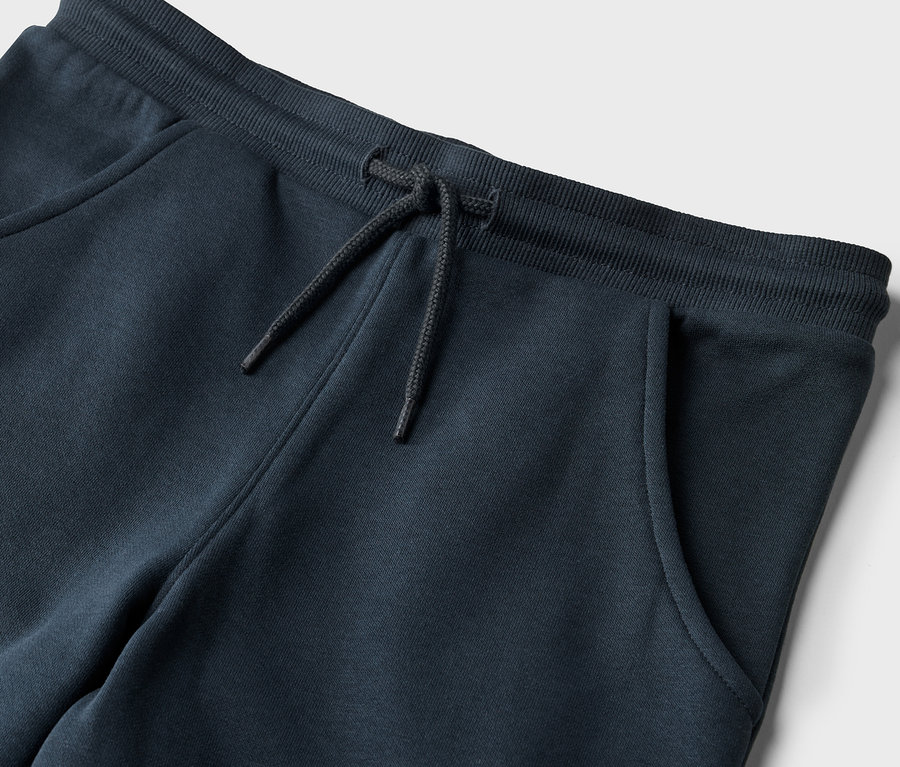 Gros plan sur un pantalon de jogging pour enfants avec cordon de serrage et poche.
