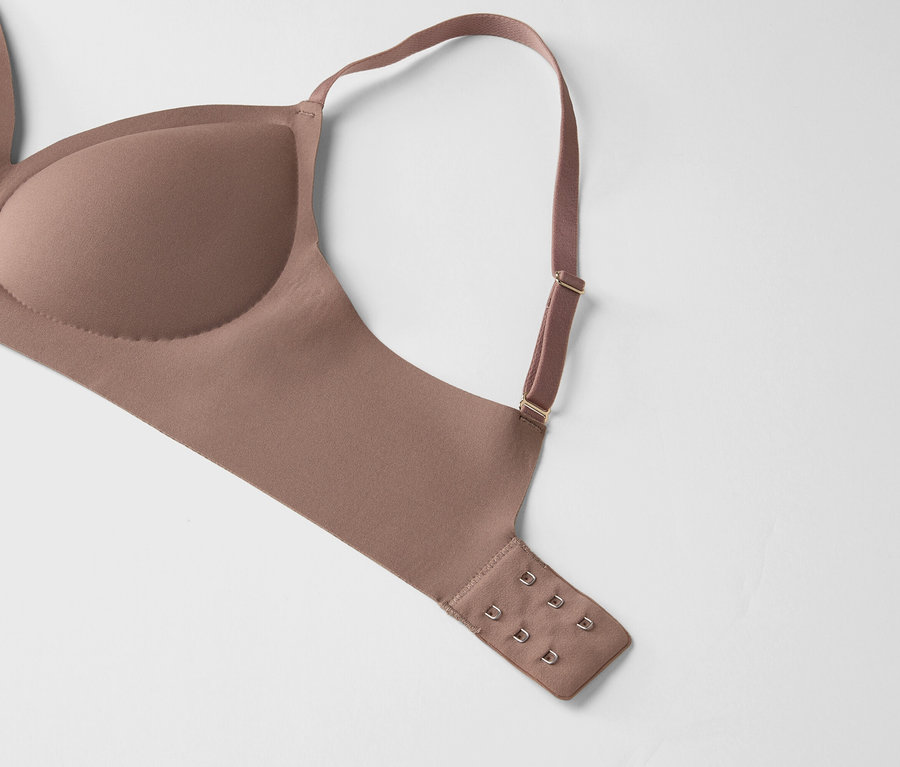 Gros plan d'un soutien-gorge beige avec une bretelle réglable sur un fond blanc.