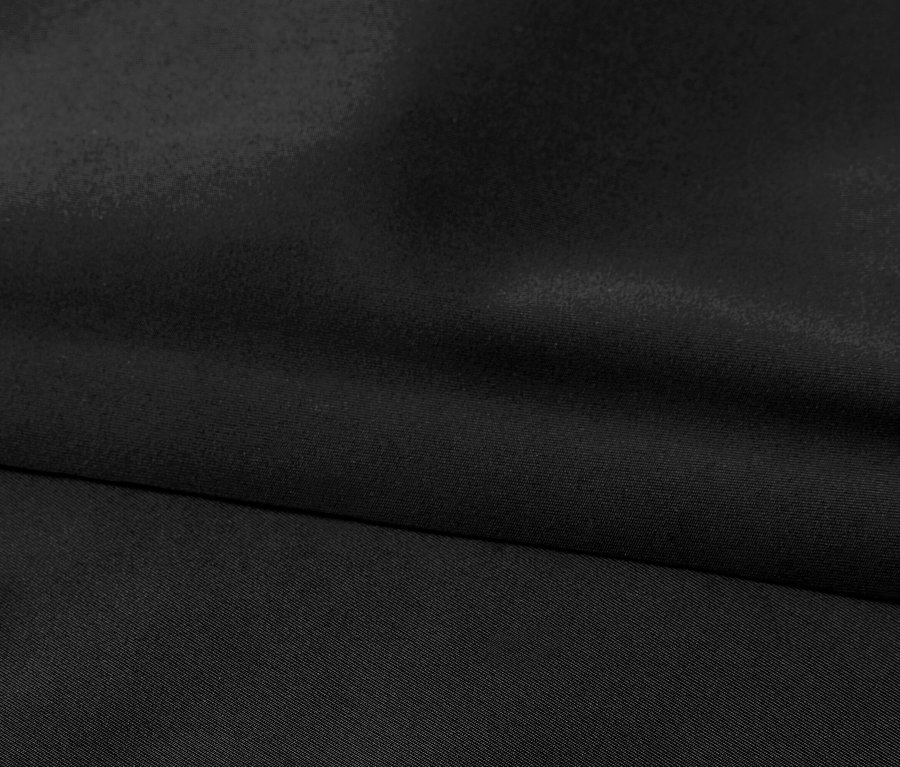 Gros plan d'un tissu noir avec de subtils plis.