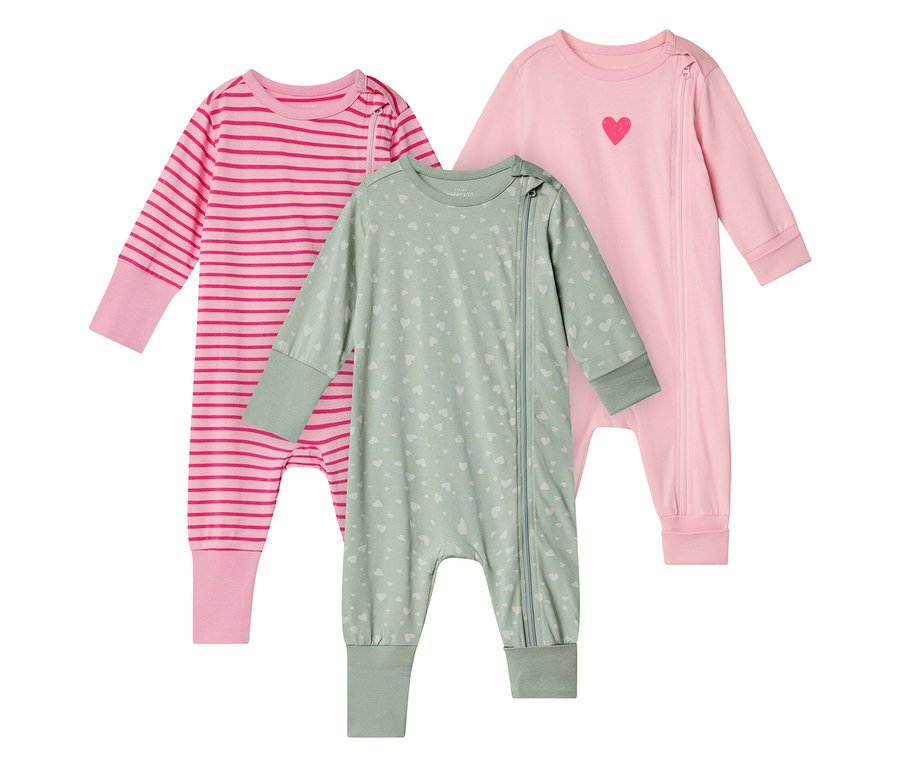 Trois pyjamas pour bébé, motifs cœurs, rayures et rose uni, chacun avec fermeture éclair.