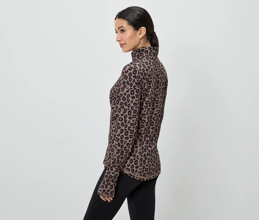 Femme portant un haut à manches longues marron à motif léopard et un legging noir, vue de côté.
