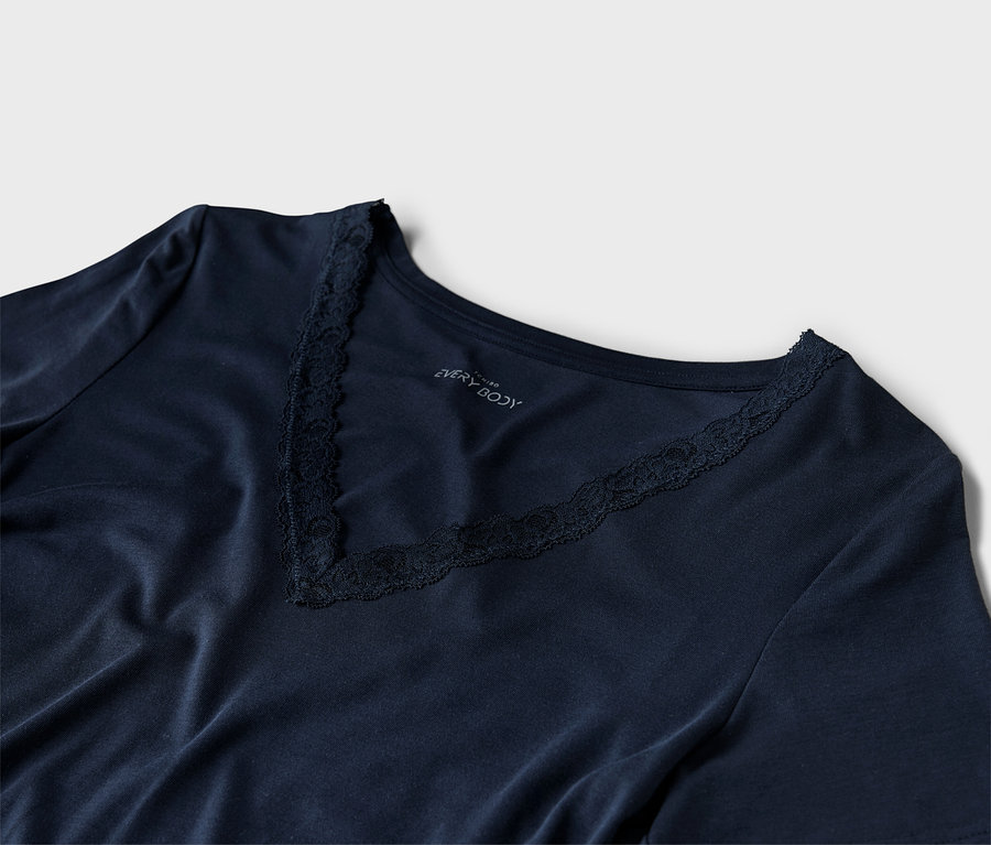 Gros plan d'un t-shirt bleu marine à col en V avec des détails en dentelle.