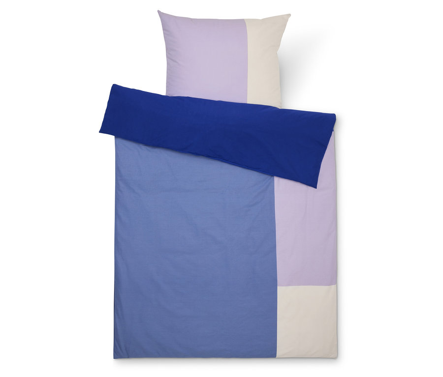 Vue de dessus d'une parure de lit à blocs de couleurs avec un drap bleu, une taie d'oreiller lavande et crème.