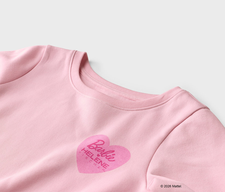 Vue détaillée d'un sweat-shirt rose avec un imprimé cœur orné du logo Barbie et du nom Helene Fischer.