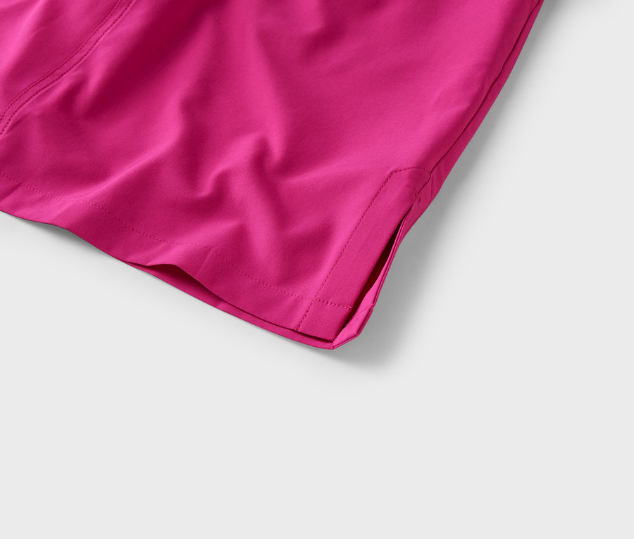 Gros plan sur le coin d'un pantalon en tissu rose avec une fente à l'ourlet.