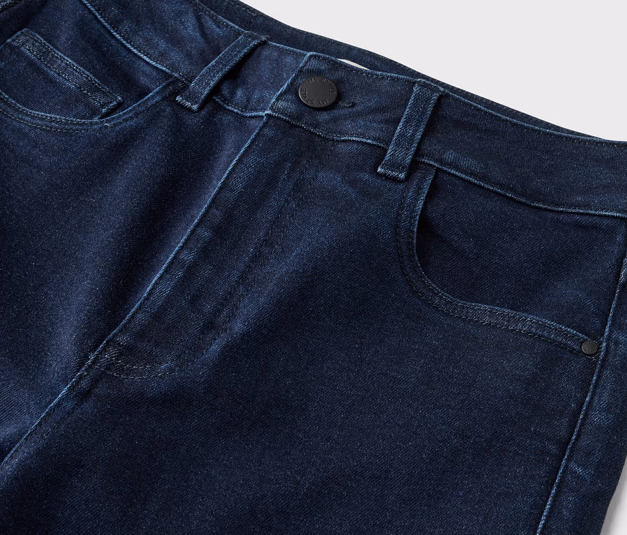 Gros plan d'un jean bleu foncé avec fermeture à bouton et poches.