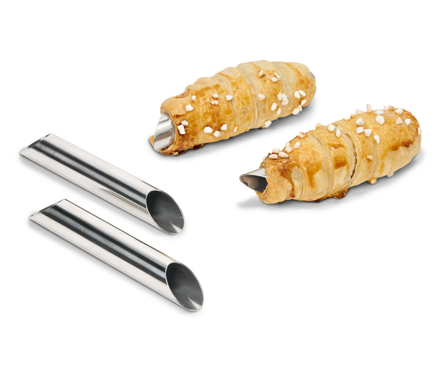 Deux rouleaux de pâte garnis de crème sont posés à côté de deux moules en métal.