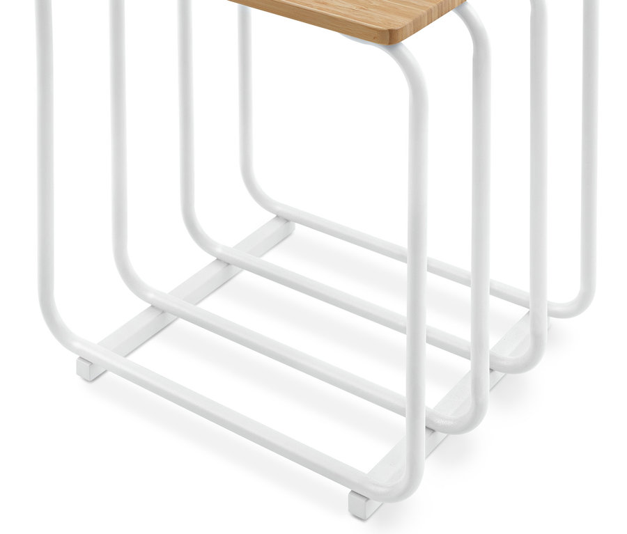 Gros plan d'un support en métal blanc avec des barres incurvées et un plateau en bois clair.