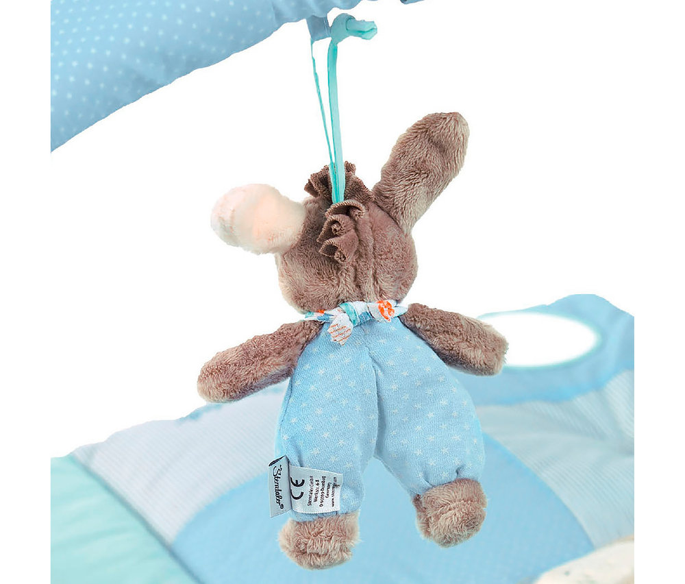 Une peluche d'âne marron avec un nez rose, vêtue d'une salopette bleu clair à étoiles et d'un foulard, pend d'une sangle bleue. Une étiquette "Sterntaler" est visible sur sa patte, sur un fond bleu et blanc.