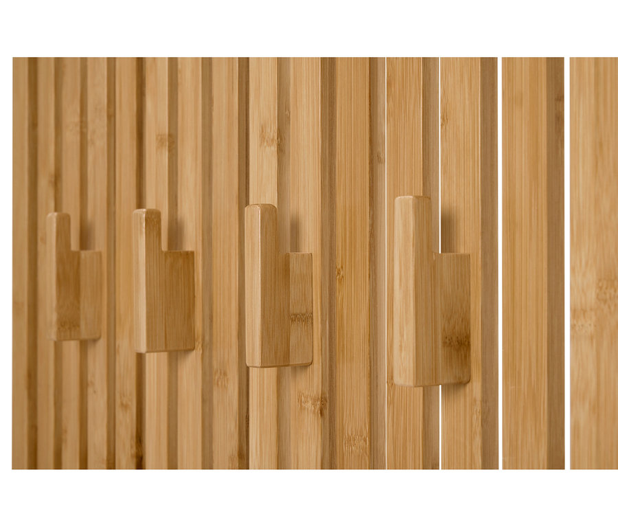 Gros plan de trois crochets à vêtements en bois sur un mur composé de panneaux de bois verticaux.