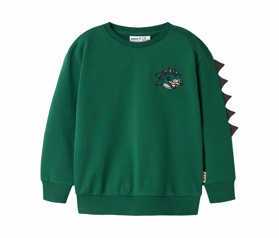 Sweat-shirt vert à manches longues avec une tête de dragon de dessin animé brodée sur la poitrine et des pointes triangulaires noires le long de la manche droite.