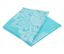 Serviette turquoise pliée avec un motif ornemental blanc.