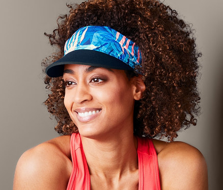 Femme avec afro porte une visière 2 en 1.