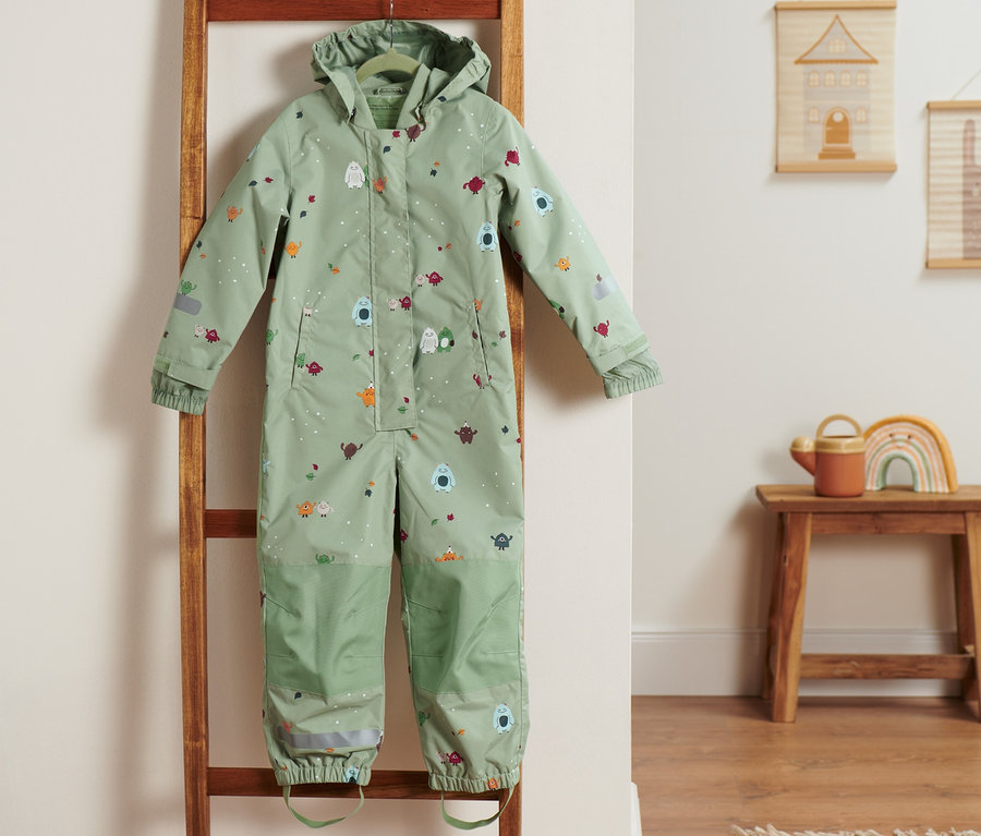 Une combinaison de pluie verte est suspendue à une échelle en bois.