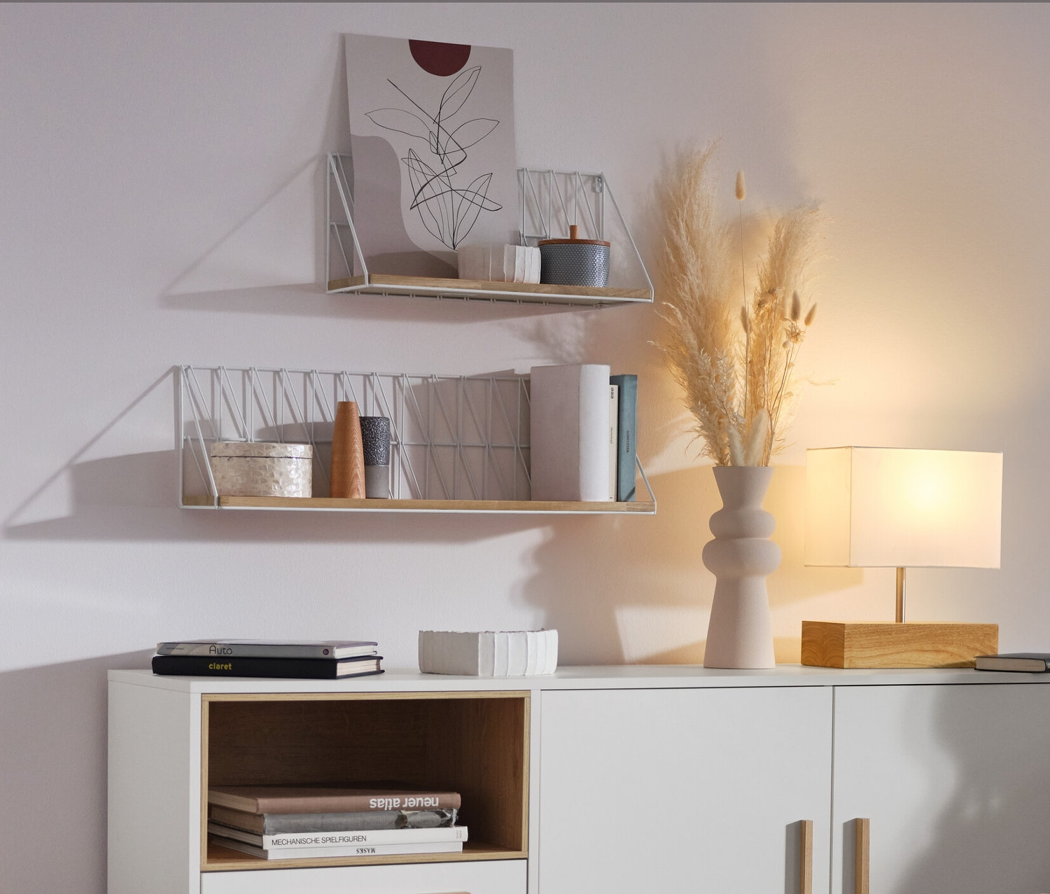 Une femme est assise dans le salon à côté d'un buffet «
Eklund
» blanc avec tiroirs et porte.