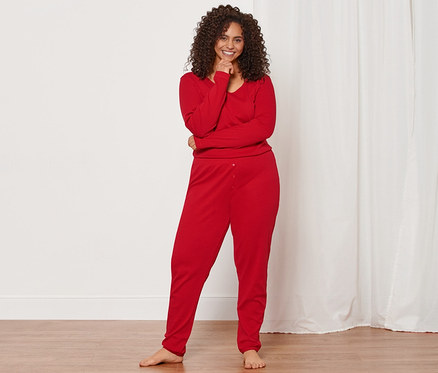 Femme debout portant un pyjama ajouré rouge.