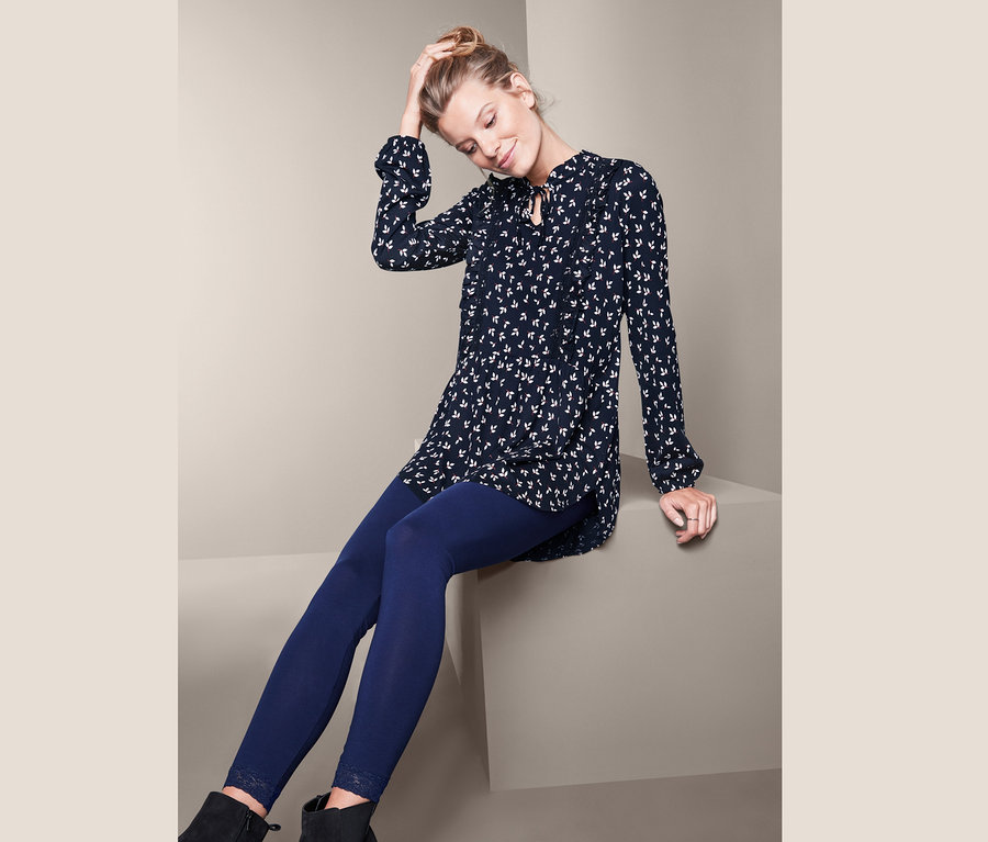 Femme assise portant un t-shirt long imprimé.