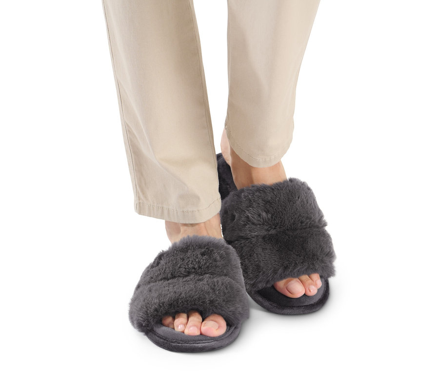Pieds en pantalon beige et chaussons en peluche.