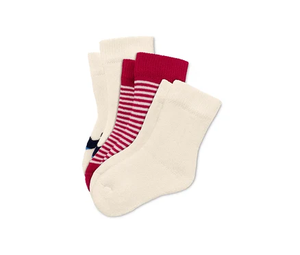 Trois paires de chaussettes pour bébé : crème, rayées rouges et crème avec des motifs bleu marine.