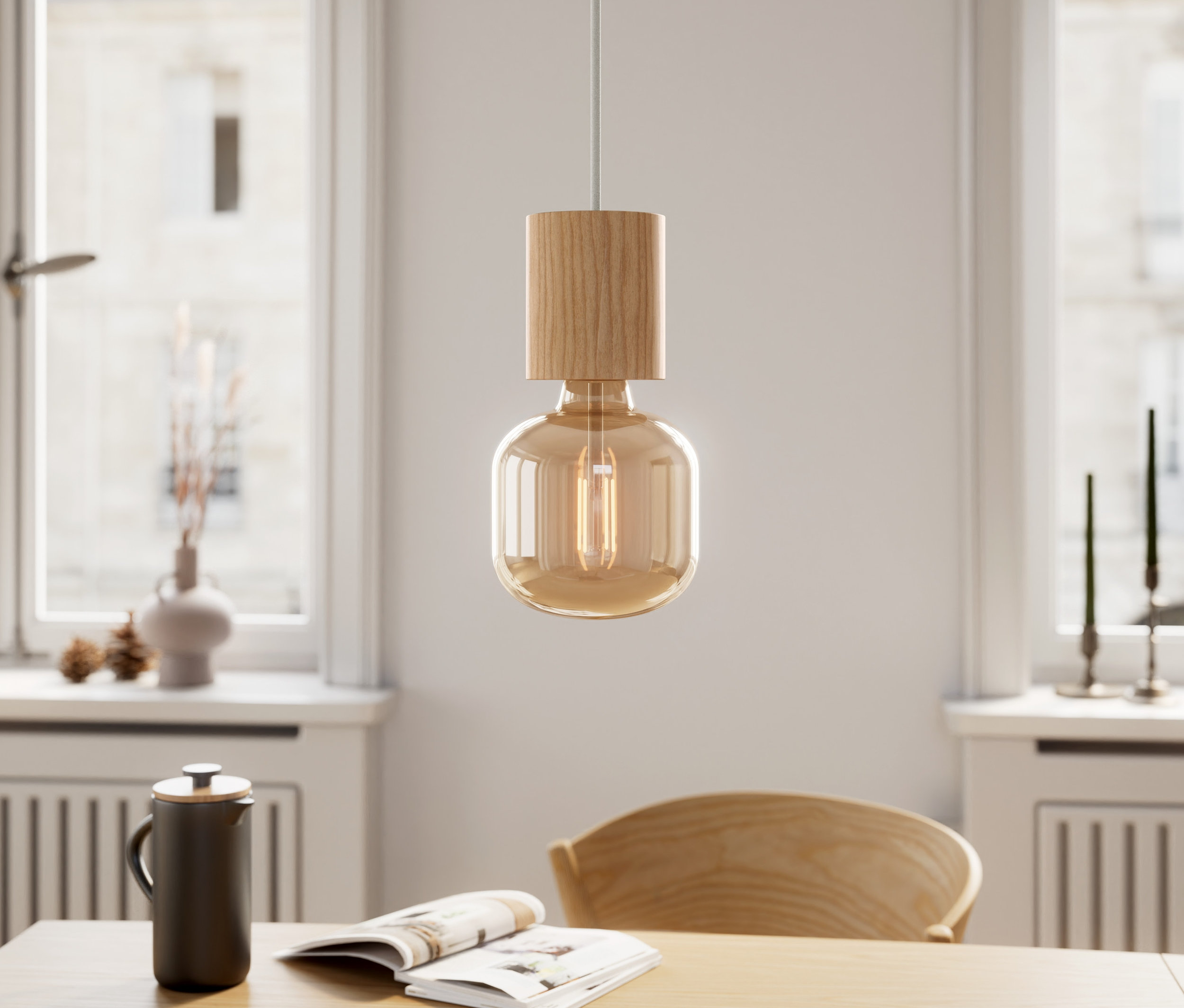 Une suspension en bois est suspendue au-dessus d'une table avec un livre et une tasse.