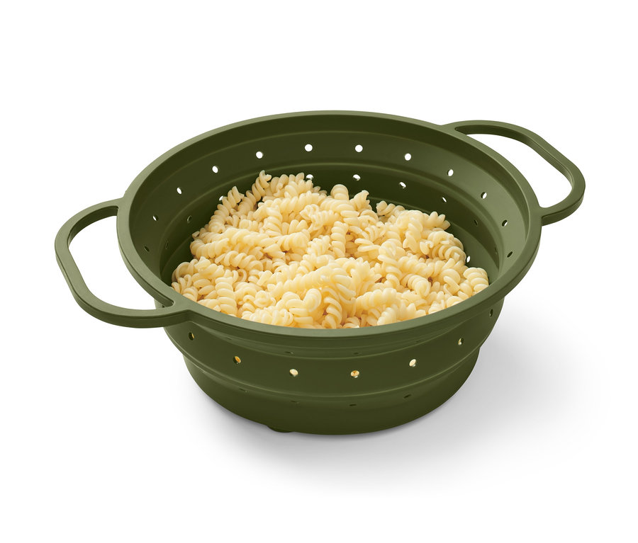 Des pâtes fusilli dans une passoire peu encombrante verte.
