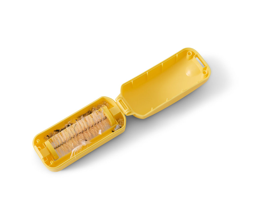 Ramasse-miettes jaune ouvert avec des saletés collectées.