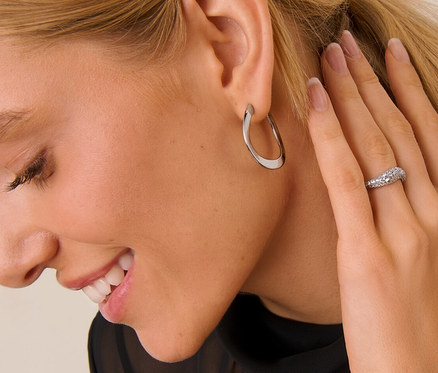 Femme blonde portant des Créoles vague et une Bague en argent 925 vague.