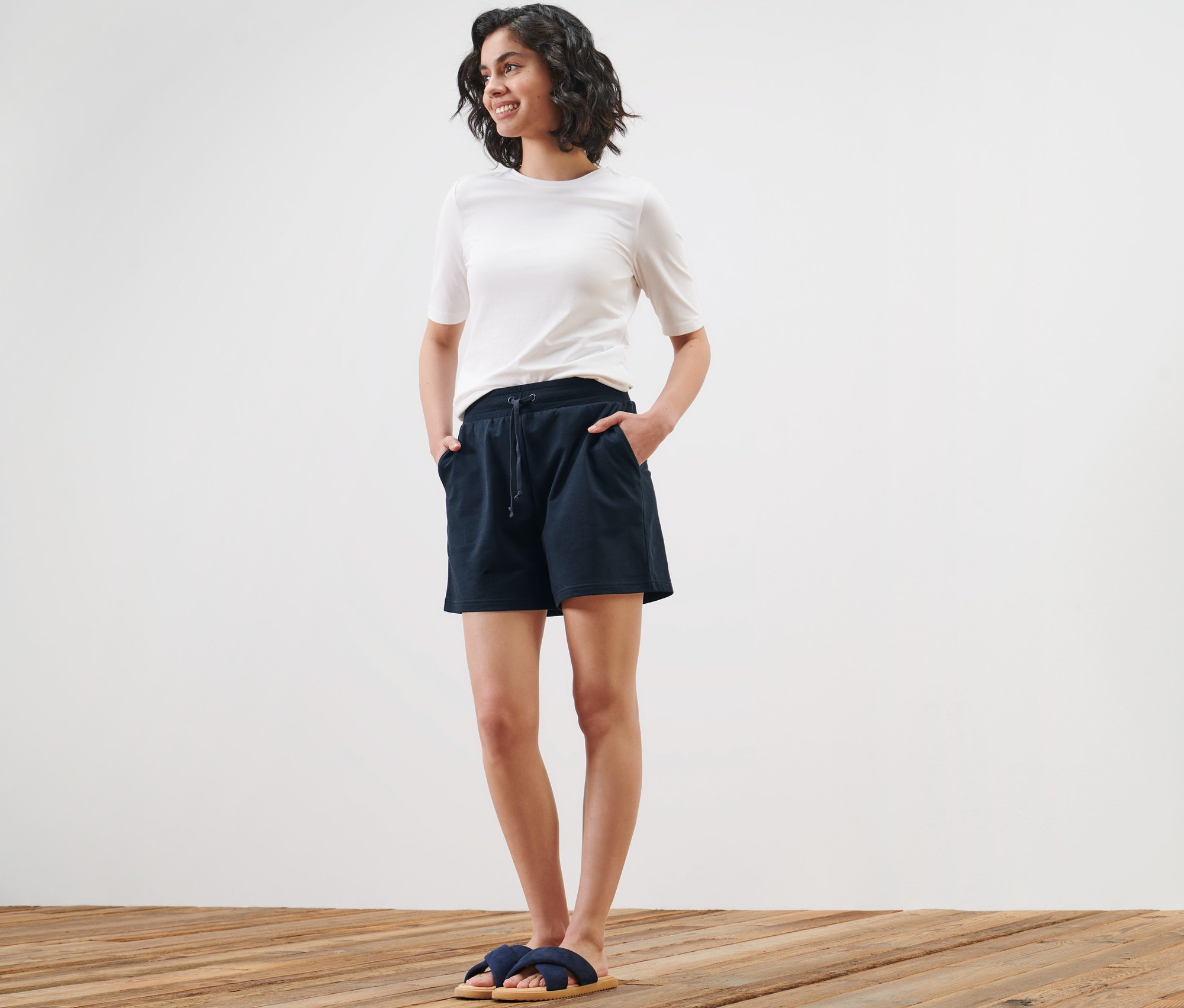 Femme posant en short en sweat et t-shirt.