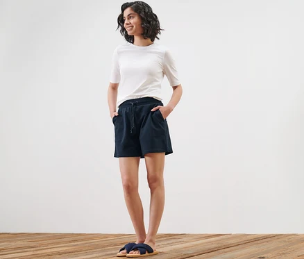 Femme posant en short en sweat et t-shirt.