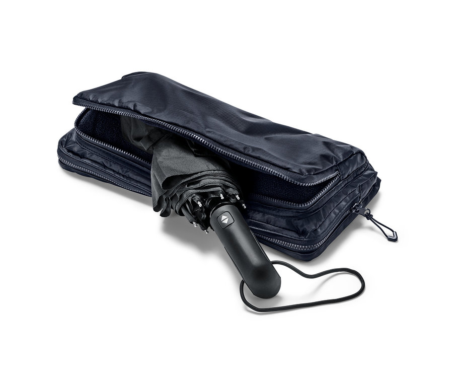 Parapluie noir partiellement inséré dans un sac à dos et tote bag 2 en 1 bleu.