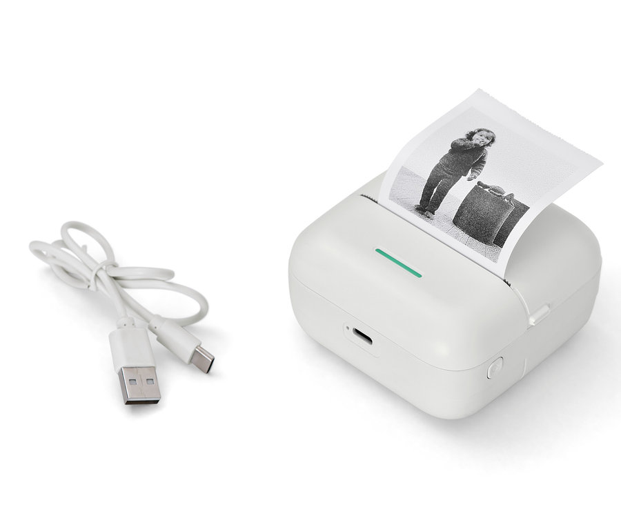 Une mini-imprimante thermique blanche avec une photo imprimée en noir et blanc et un câble USB.