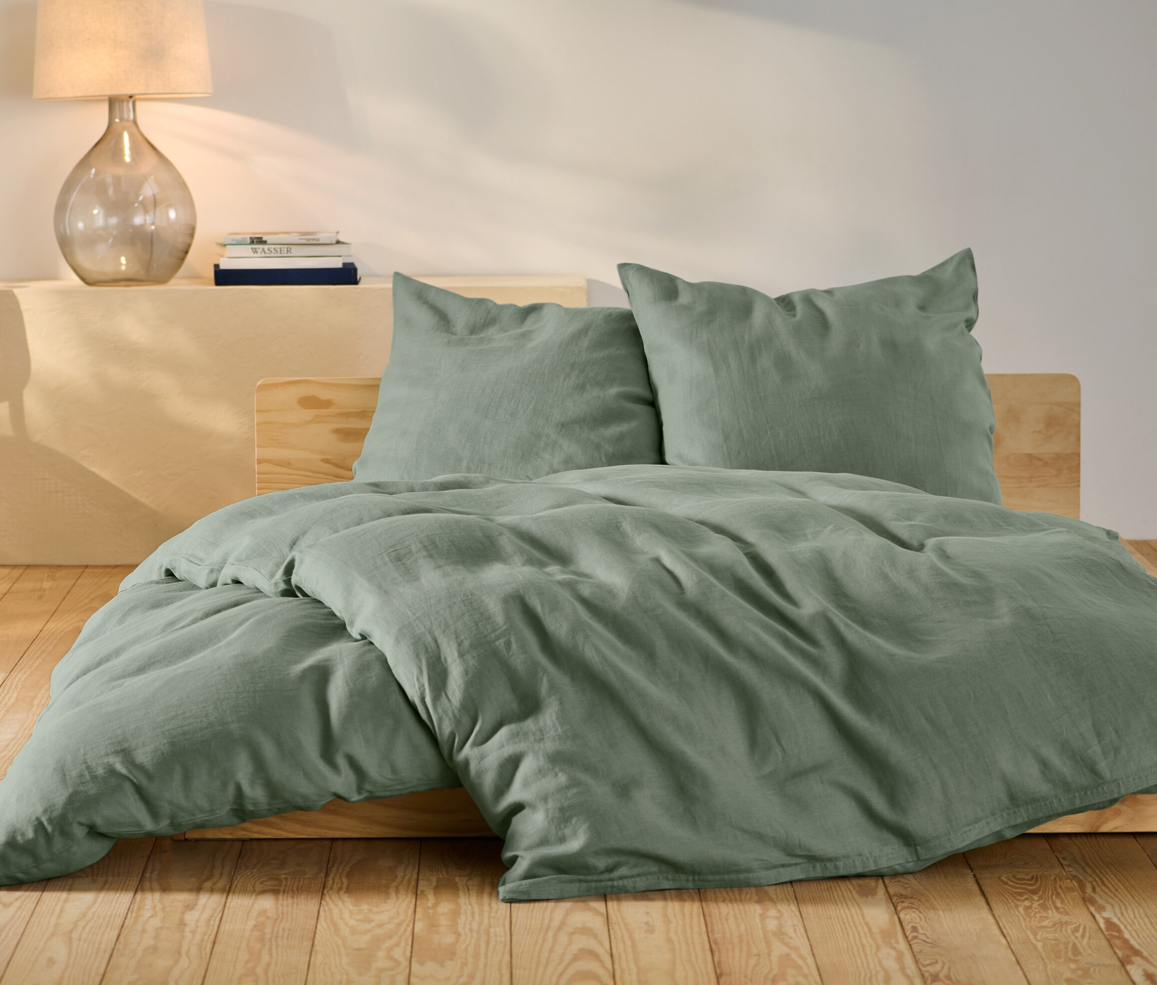Parure de lit en lin verte de taille standard et grande taille sur un lit.
