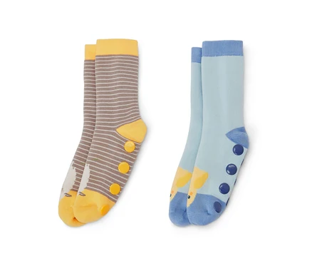 Deux paires de chaussettes anti-dérapantes pour enfant. Une paire est rayée marron et blanc avec des détails jaunes et une image d'oiseau, l'autre paire est bleu clair avec une image de girafe et des points bleu foncé.