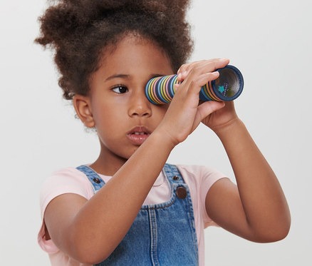 Une fille regarde dans un caléidoscope.
