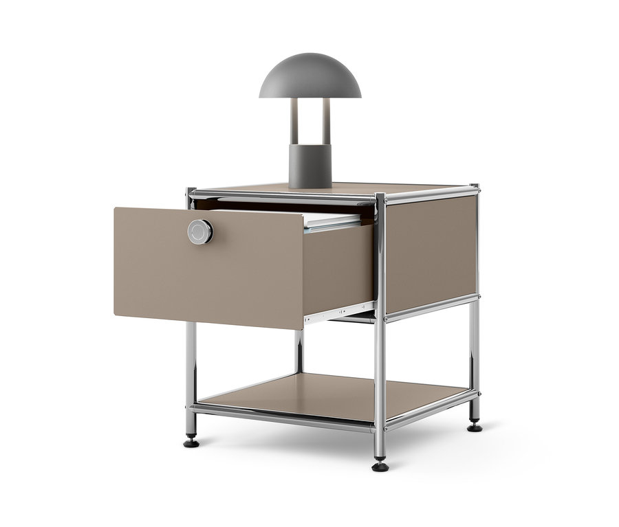 Table d'appoint beige en métal « CN3 » avec un tiroir ouvert et une lampe grise sur le dessus.