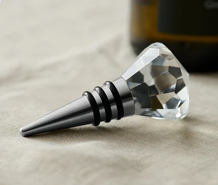 Un bouchon de bouteille avec une décoration en cristal sur une nappe beige.