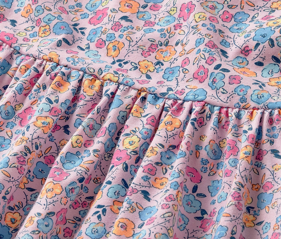Gros plan sur une robe en jersey pour enfant avec un motif floral.