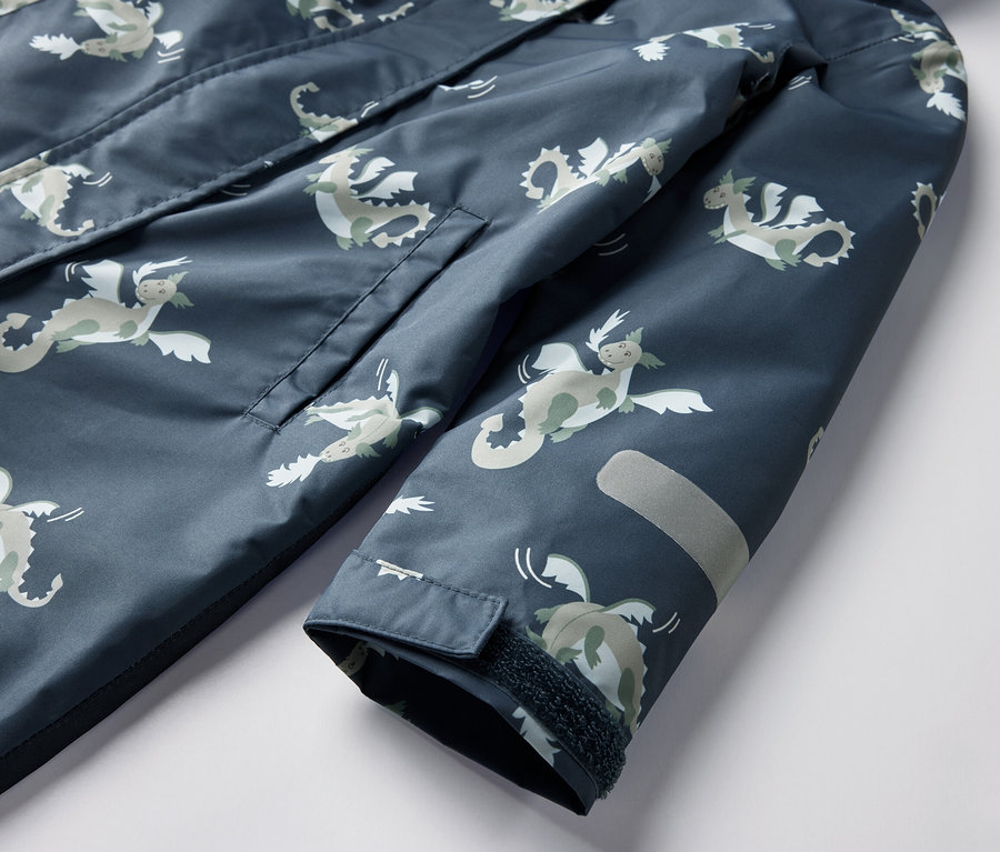 Gros plan sur une combinaison de pluie pour enfant, motif chevalier, avec poche et réflecteur.