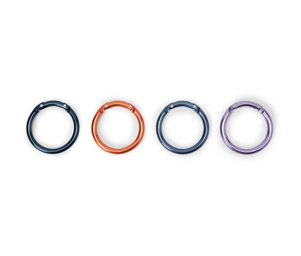 Quatre mousquetons de couleurs différentes sont posés sur un fond blanc.